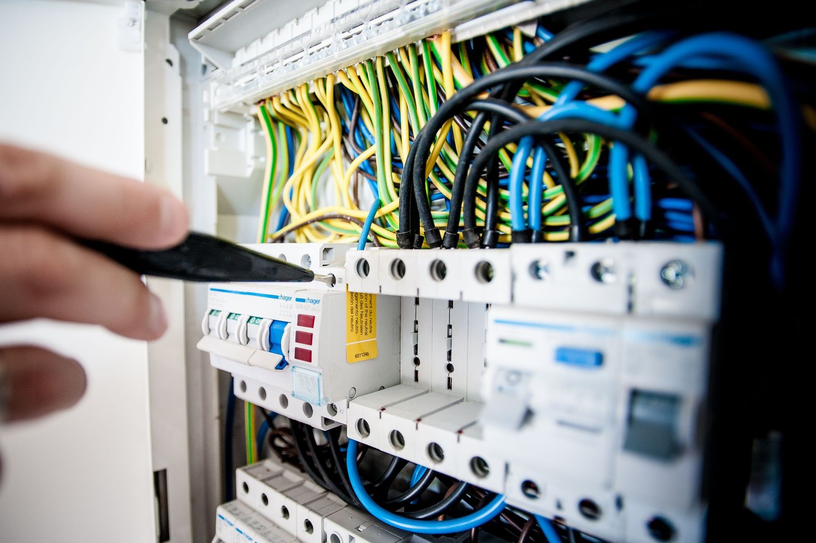 Electrician inspecting a distribution board during a maintenance visit