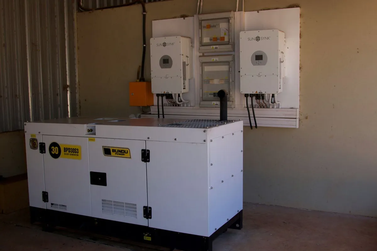Hybrid battery inverters and distribution boards installed in a plant room, with a standby generator